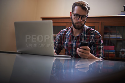 Buy stock photo Man, laptop and phone for remote work, night and typing or check email for communication. Male person, freelancer and reading notification in home, research and browse on internet or app and website