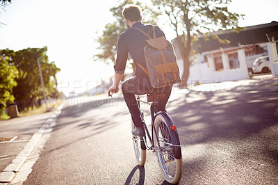 Buy stock photo Bicycle, transport and back of man in street on lens flare for exercise, commute and cycling in morning. Travel, city and male cyclist on bike for eco friendly traveling, carbon footprint and journey