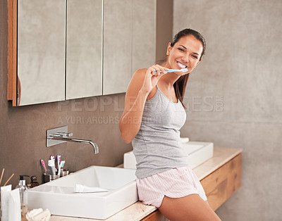 Buy stock photo A portrait of a beautiful young woman brushing her teeth in her bathroom