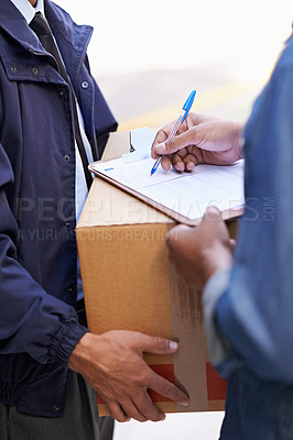 Buy stock photo A friendly delivery man delivering a package to a home