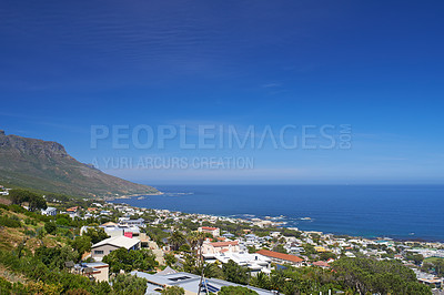 Buy stock photo High angle of a seaside town on a mountain against a clear blue sky on a bright summer day outside. A small beach town in nature. Scenic coastline in Camps Bay, Cape Town, South Africa