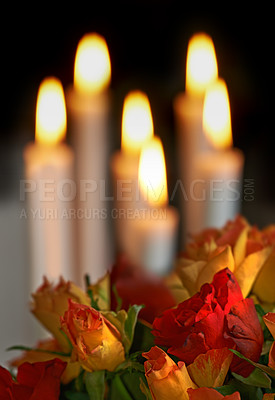 Buy stock photo Fresh colourful roses with lit candles in the background against dark copyspace. A romantic gesture, proposal, valentines day, birthday celebration or an apology, perfect setting for a date night