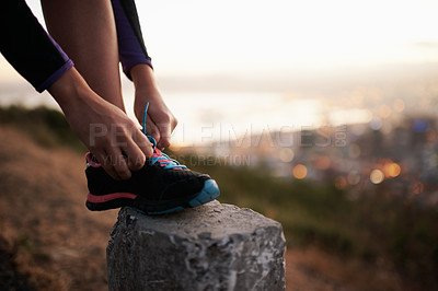 Buy stock photo Cropped shot of a runner tying her shoelaces