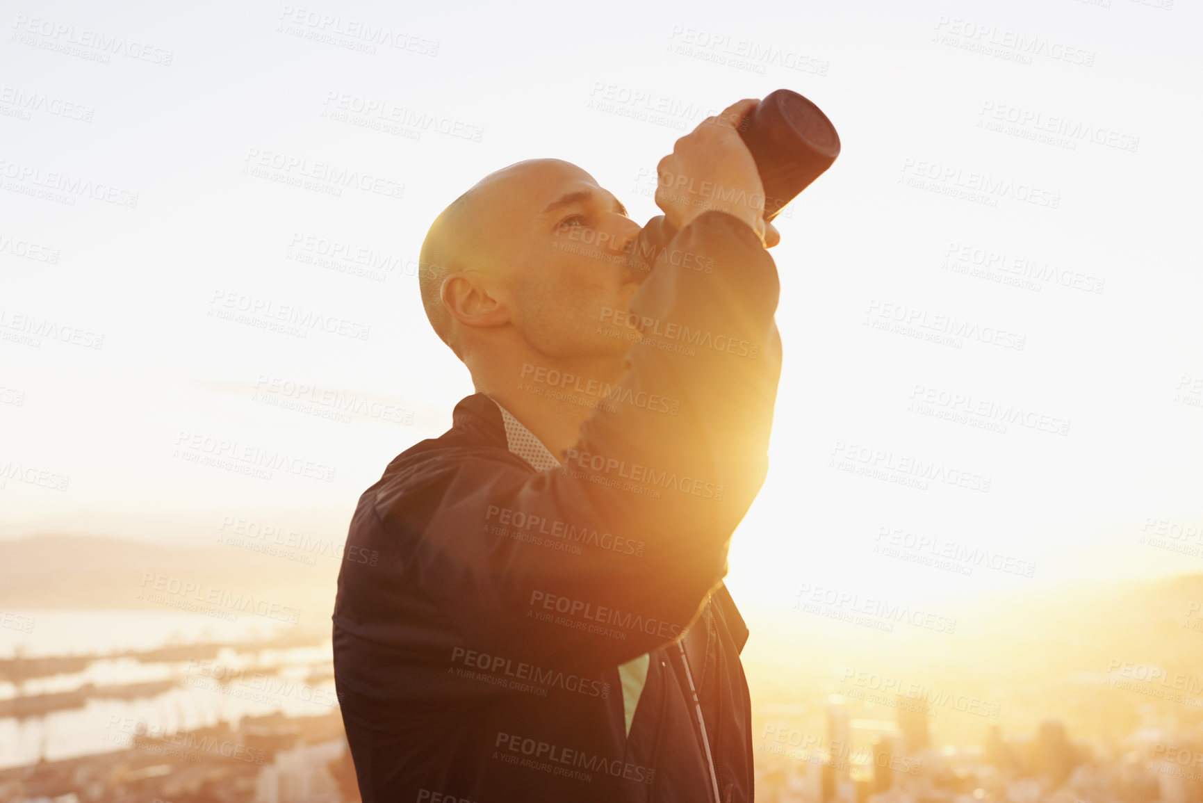 Buy stock photo Man, fitness and drinking water with sunset for natural sustainability, break or outdoor hydration. Thirsty male person or athlete with liquid bottle after workout, exercise or training in nature