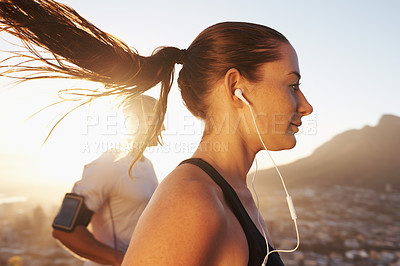 Buy stock photo Sunrise, streaming and woman running as exercise or morning workout for health and wellness together. Sport, man and runner run with athlete while training and listening to sports music for energy