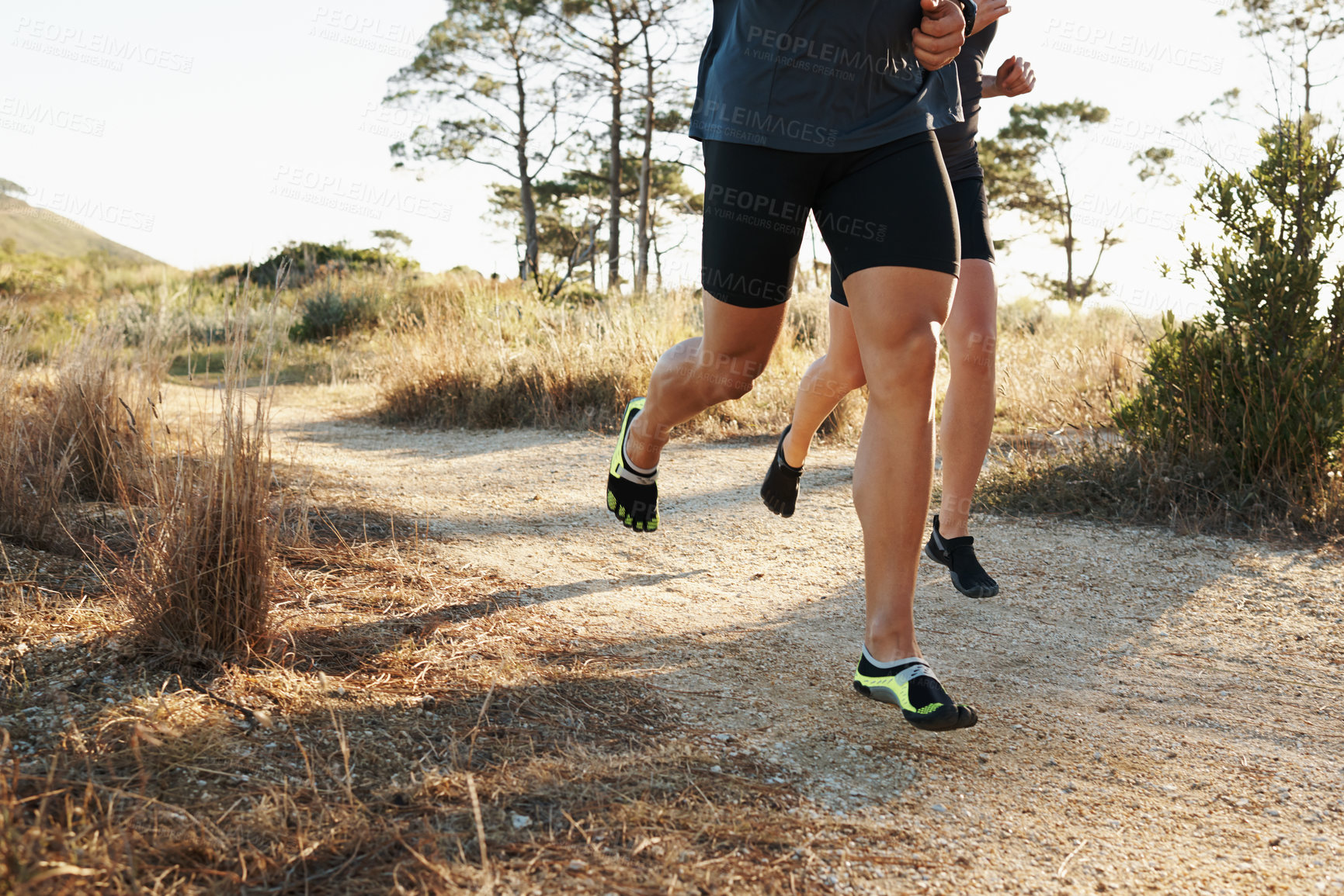 Buy stock photo Closeup, people and legs with running for fitness, exercise or outdoor training on dirt road. Person and runner with sports shoes or footwear for hiking, trekking or cardio workout together in nature