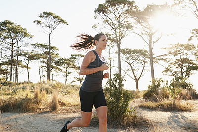 Buy stock photo Training, running and woman on road in forest for health, wellness and strong body development. Workout, exercise and girl runner on path in nature for marathon fitness, performance and challenge.