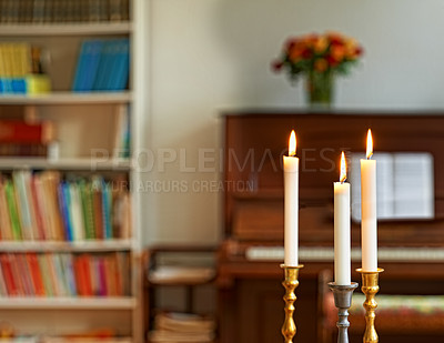 Buy stock photo Three thin candles in candle stick holders burning against the blurry piano and bouquet of flowers background. Elegant candle lights in gold and silver holders, for weddings, funeral home, or church