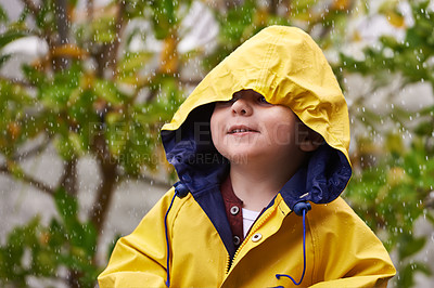Buy stock photo Child, rain and raincoat outdoor in winter for fashion, jacket and cold weather in London. Little boy, male toddler and kid in drizzle by tree, bokeh or environment with windbreaker for chilly season