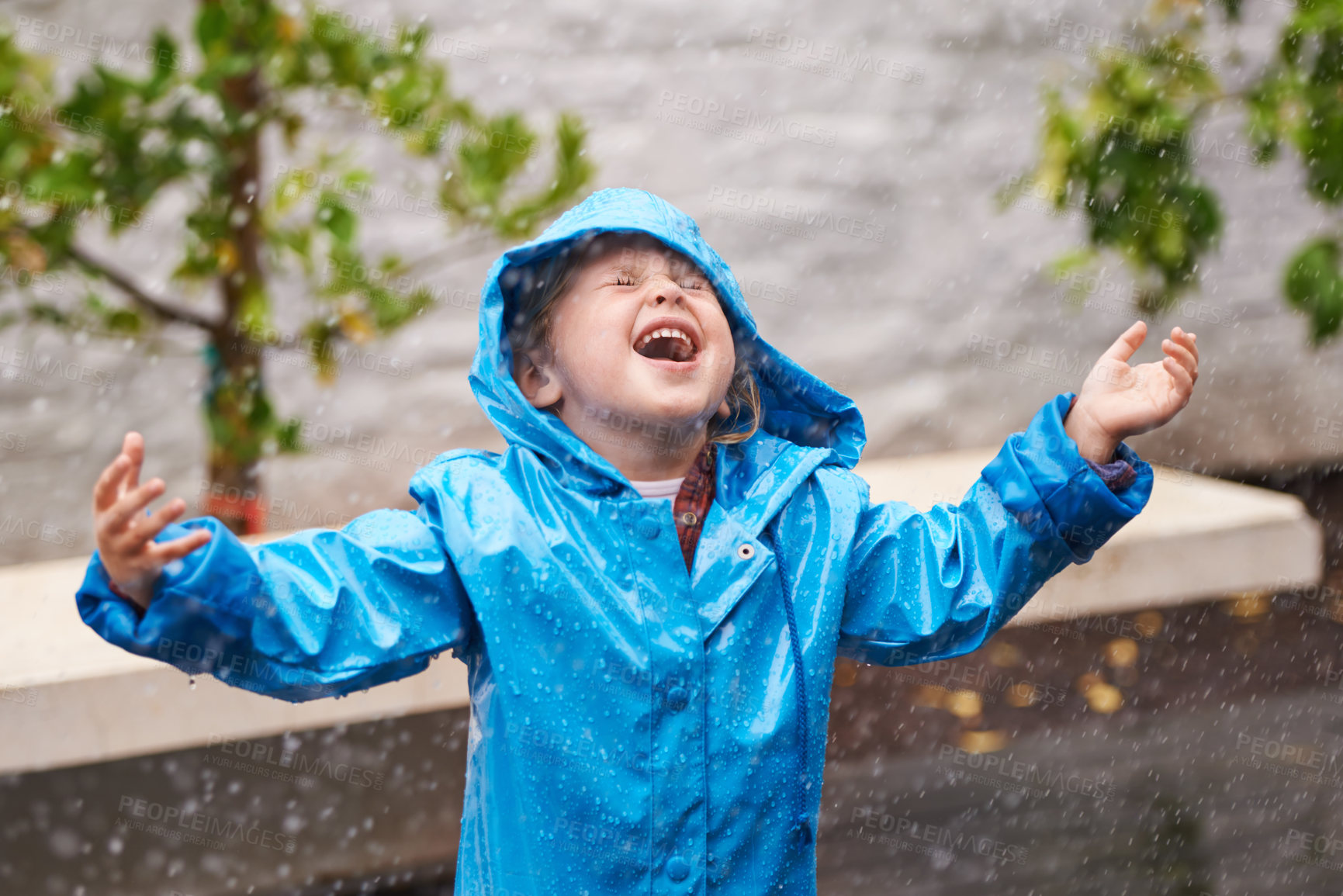 Buy stock photo Winter, rain coat and a girl playing in the weather outdoor alone, having fun during the cold season. Children, water or wet with an adorable small female kid standing arms outstretched outside