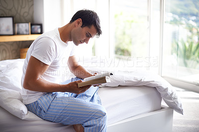 Buy stock photo Man, reading and relax for morning, book and sleepwear in bedroom for wellness and literature for class. Male person, hobby and student for relaxation, leisure and novel for home free time in house