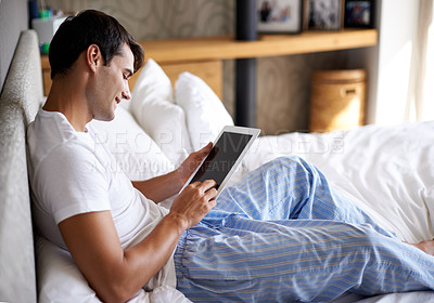 Buy stock photo Man, smile and bed with tablet for communication, internet and technology in bedroom, home and apartment in morning time. Male person, student and digital pad on social media, browsing and online