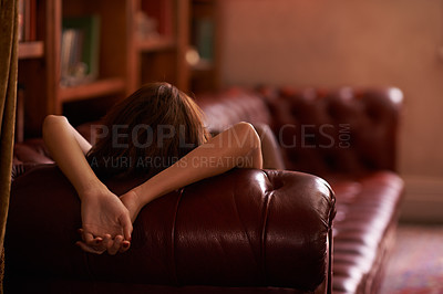 Buy stock photo Rear view shot of a young woman relaxing on a sofa in the study