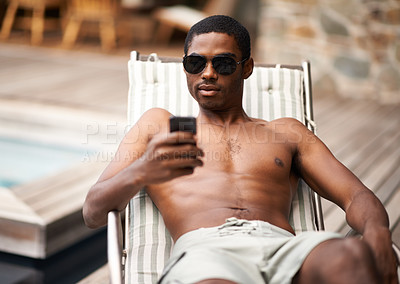 Buy stock photo Happy man, browse and relax on deckchair, phone and scroll on social media on summer holiday. Black male person, smile and online for blog or app for chat on travel to Nigeria, vacation and outdoors