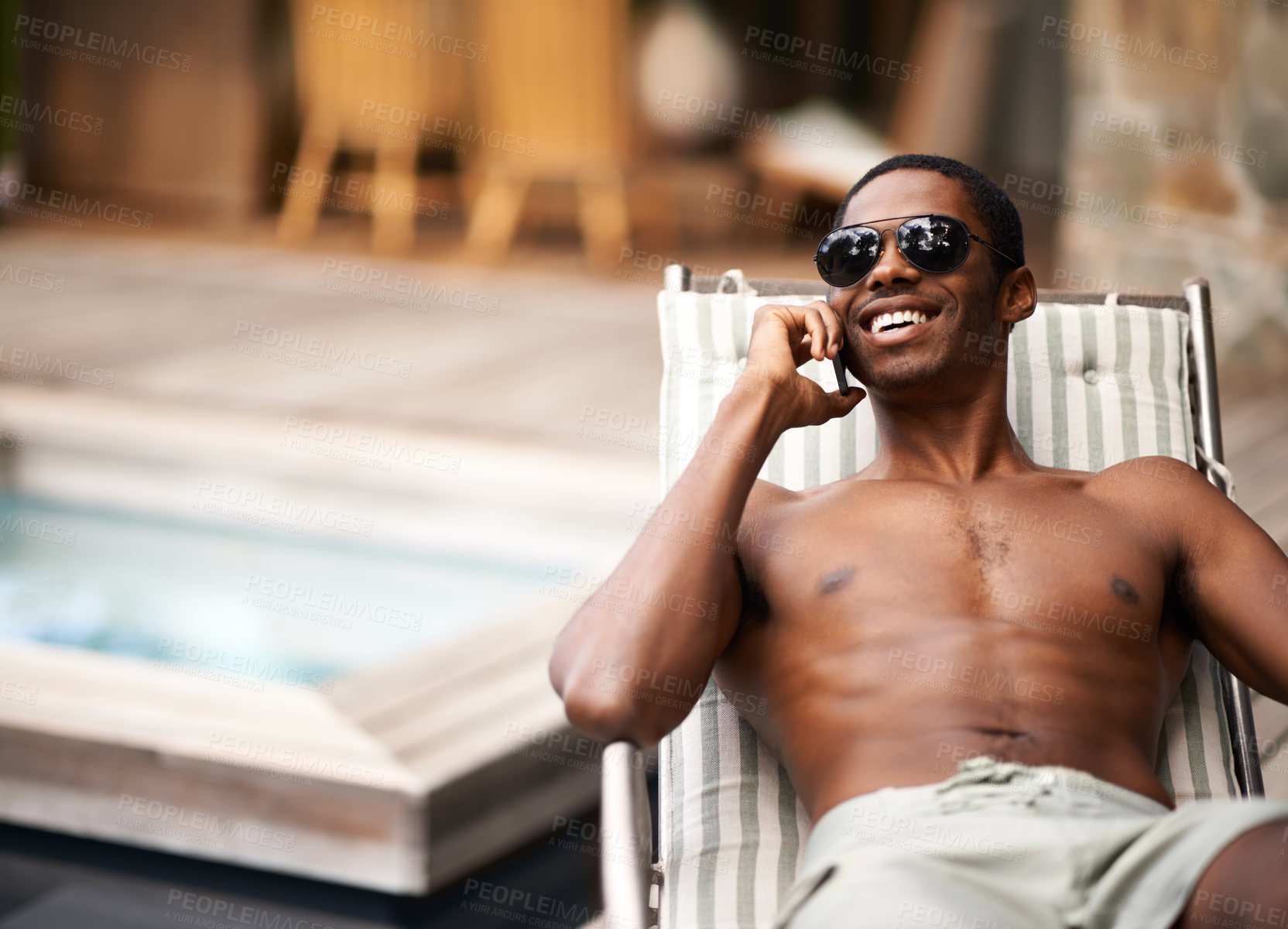 Buy stock photo Man, happy and relax on deckchair, phone call and communication on summer holiday. Black male person, smile and voip for conversation, app and networking on travel to Nigeria, vacation and outdoors