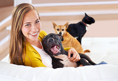 Buy stock photo Portrait of an attractive young woman sitting with her pets on the sofa
