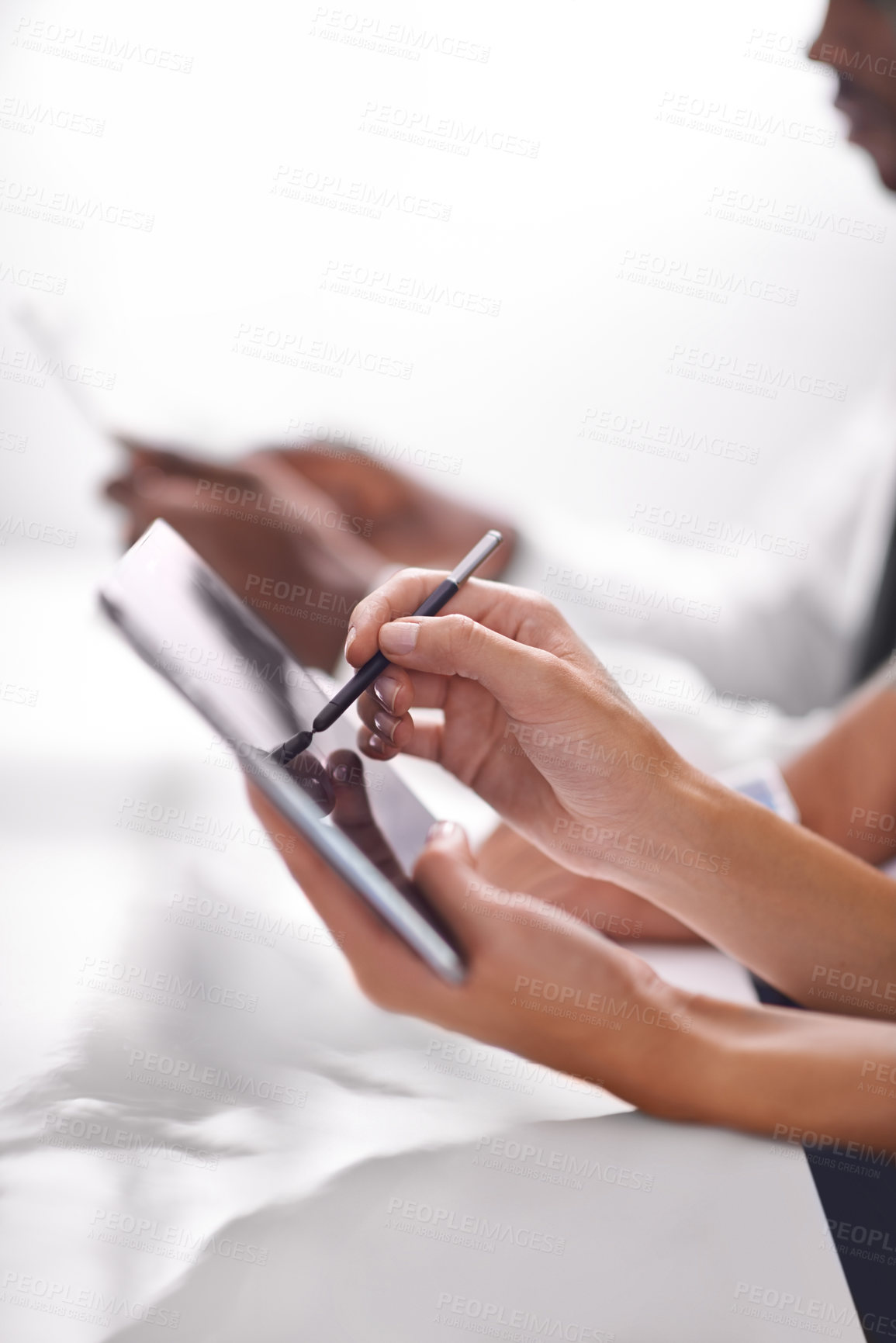 Buy stock photo Cropped shot of two businesspeople using their touchpads