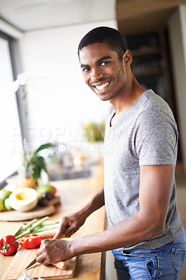 Buy stock photo African, man and kitchen cooking and chopping, smiling and relaxed happy morning at counter. Confident and male person, food and culinary in apartment, nutrition and organic vegetable for breakfast