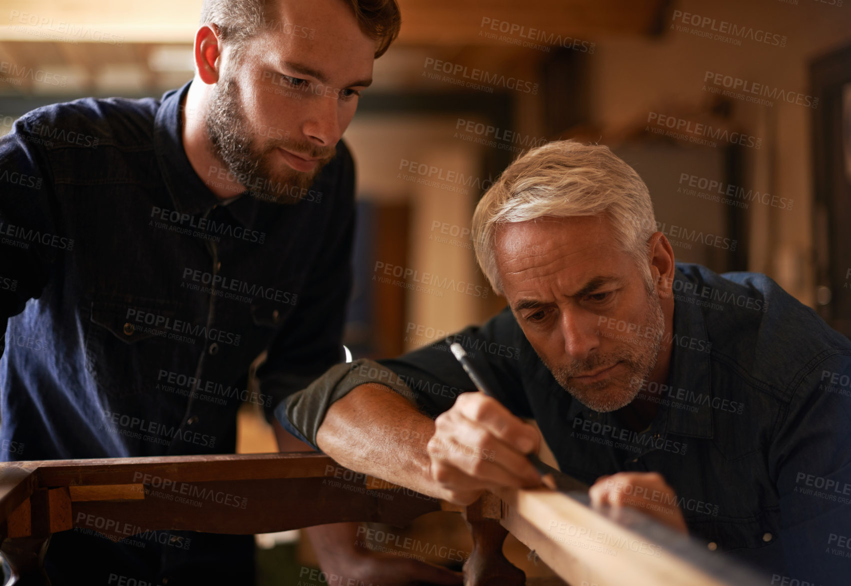 Buy stock photo Teaching, learning and carpentry apprentice and help with pencil in designer furniture manufacturing workshop. Mentorship, carpenter and young man, wood and teamwork at sustainable business project.