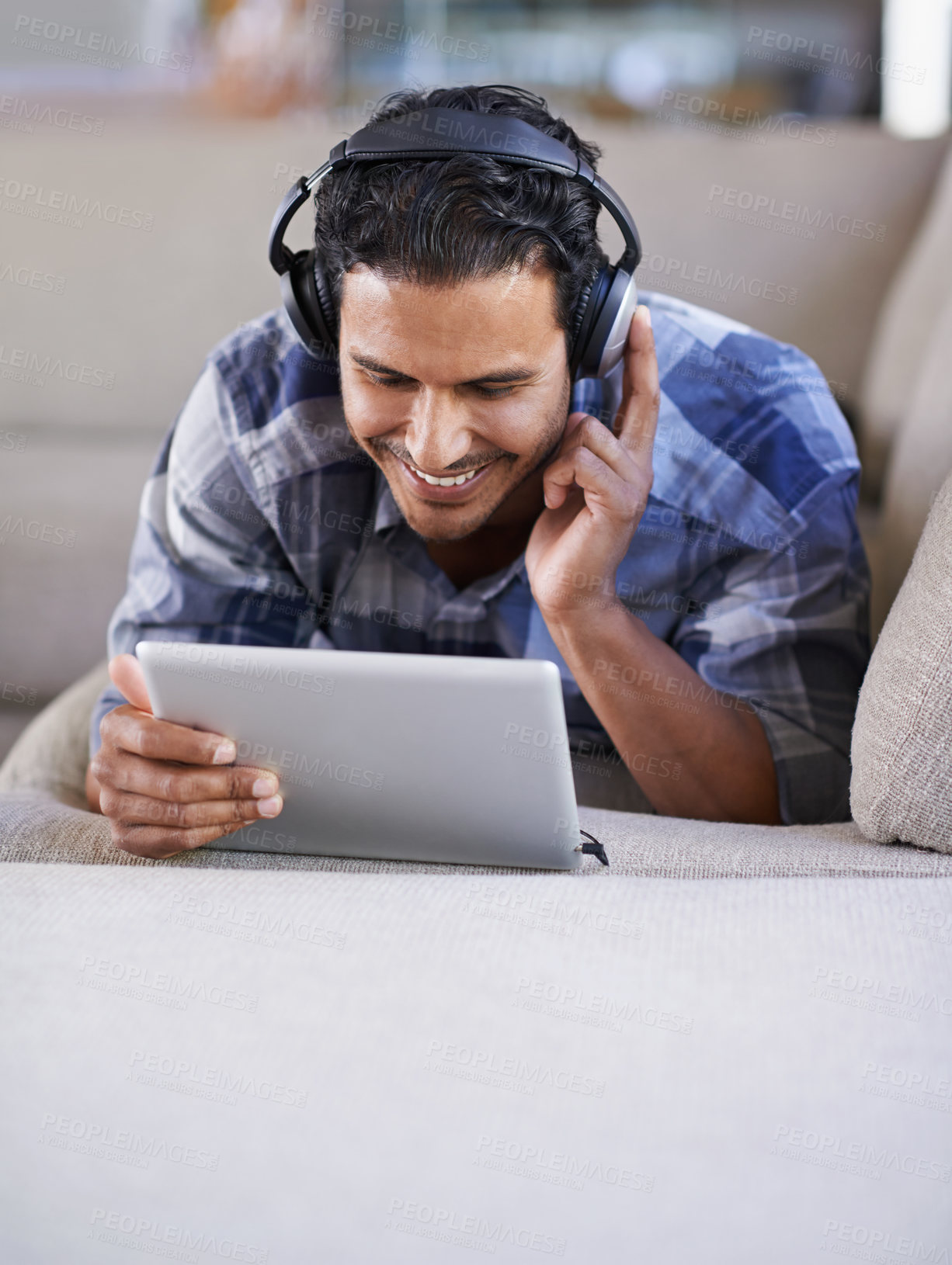 Buy stock photo A young man listening to music on his digital tablet