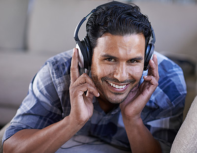 Buy stock photo Man, headphones and portrait for song on couch, relax and streaming radio for music or sound. Happy male person, home and lying on sofa for peace, comfortable and hearing jazz playlist on weekend