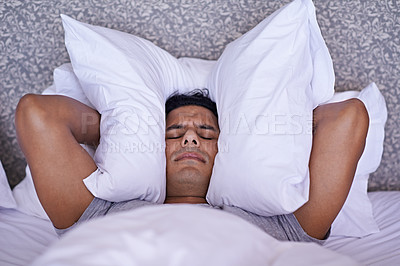 Buy stock photo Man, noise or insomnia in bedroom to rest, tired or cover ears with pillow for crisis of loud issue. Person, frustrated and mad for sound or sleep problem, anxiety and headache or stress in home