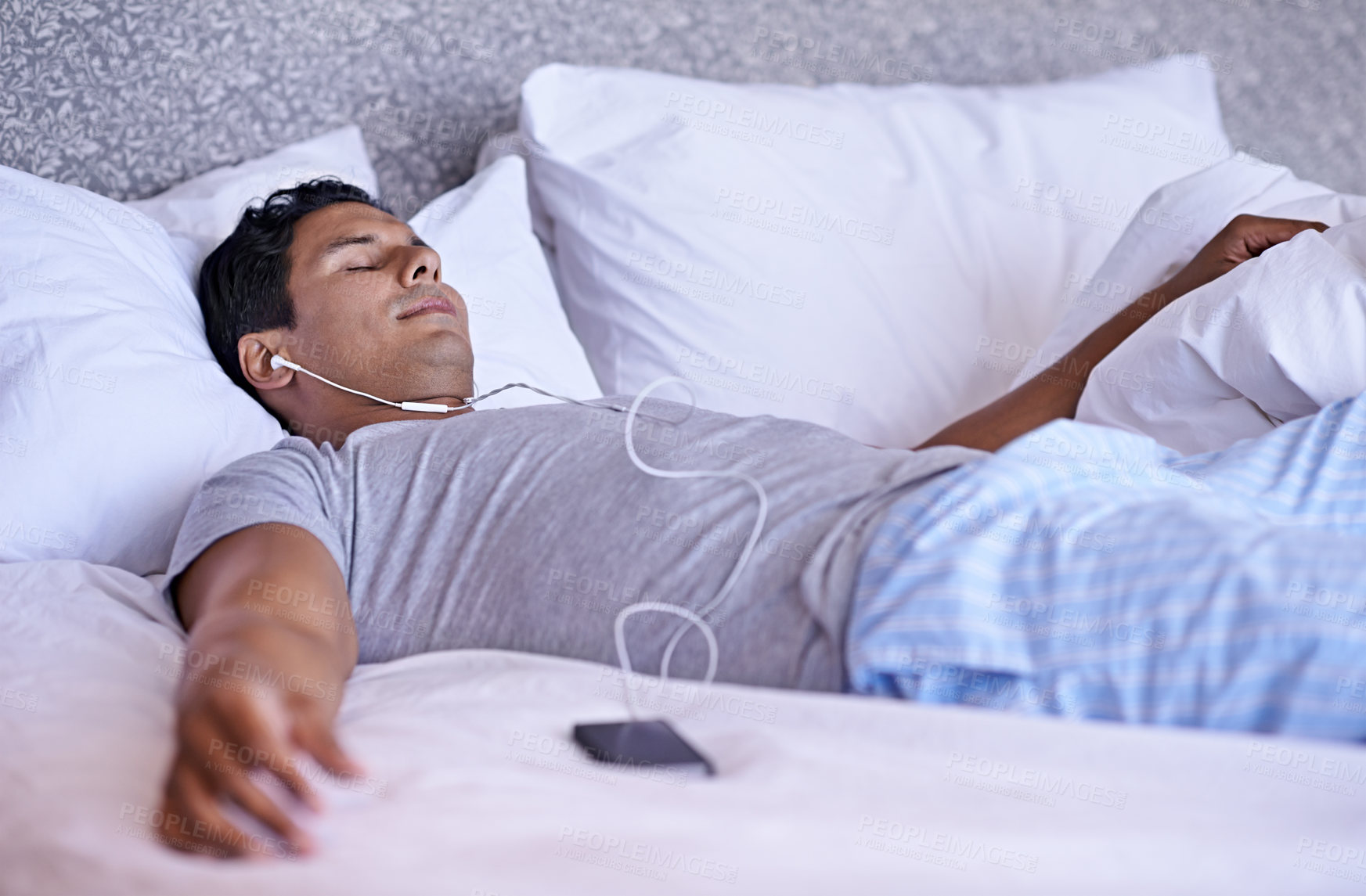 Buy stock photo Man, music and cellphone in bed to relax, tired and audio podcast or audiobook for peace on weekend. Calm person, dream and rest on mobile for online meditation, happy and listening to radio in home