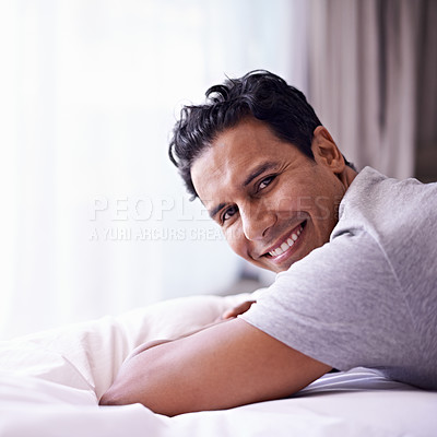 Buy stock photo Man, happy and calm in bedroom in portrait, wellness and confident person on morning in home. Young guy, positive face and healthy on break on lazy weekend, pyjamas and satisfied on bed in apartment