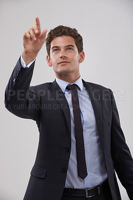 Buy stock photo Future, innovation and pointing with businessman user in studio on white background for metaverse access. Corporate, digital transformation and network interface with young employee in suit at work