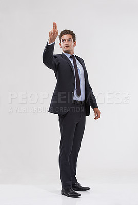 Buy stock photo A handsome young businessman pointing