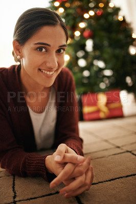Buy stock photo Portrait of an attractive young woman with a Christmas tree behind her