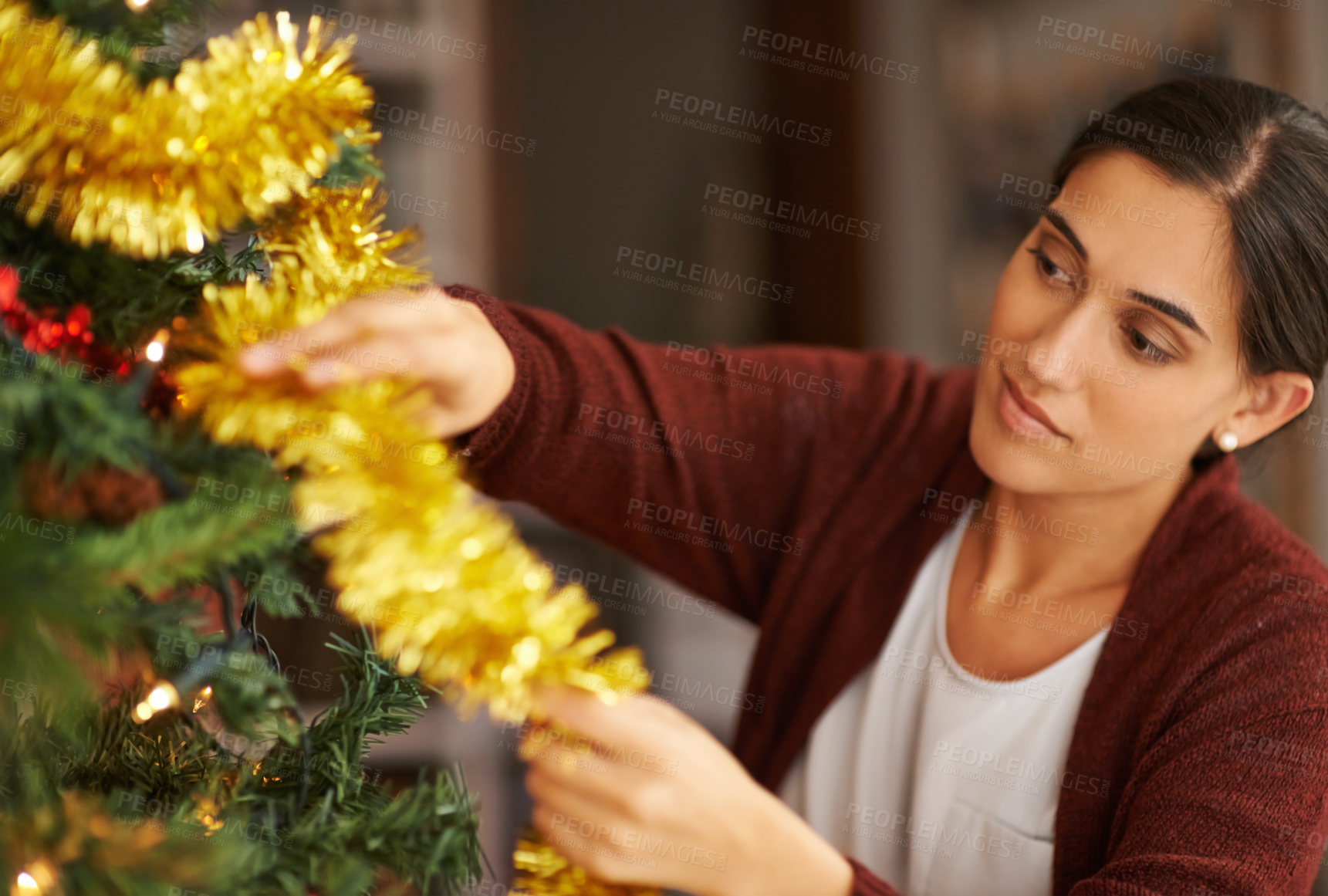 Buy stock photo Cropped shot of an attractive young woman decorating her Christmas tree
