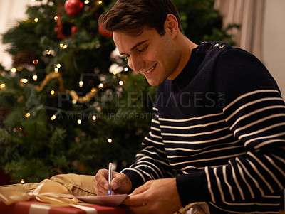 Buy stock photo Writing, Christmas tree and man with gift in home for preparation of holiday event of tradition. Box, card and present with happy young person in apartment for December celebration or vacation