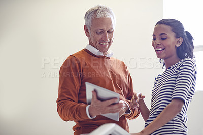 Buy stock photo Shot of a coworkers standing in a stairwell talking over a digital tablet