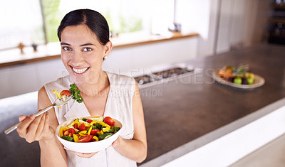 Buy stock photo Eating, salad and portrait of woman in kitchen with healthy food for lunch with nutrition in diet. Happy, wellness and hungry vegan person with a smile for fruits, vegetables or benefits to digestion