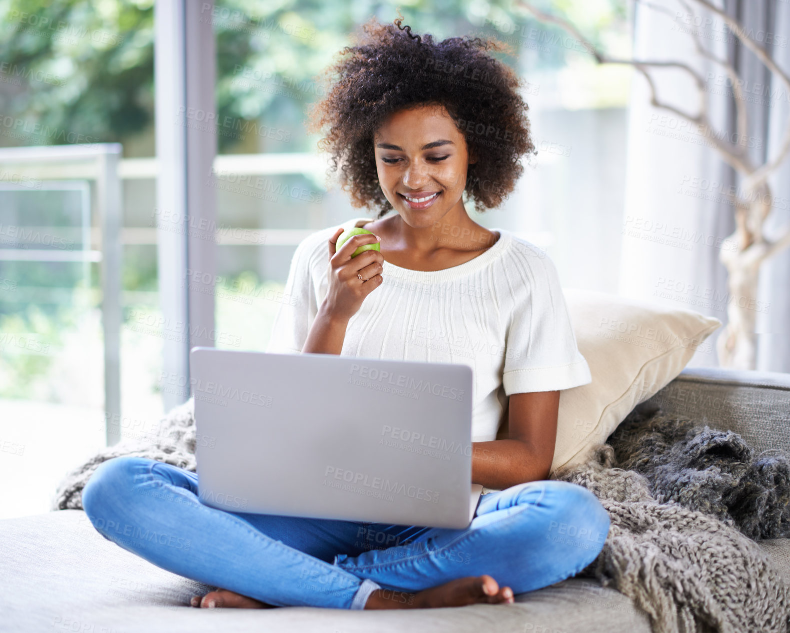 Buy stock photo Apple, smile and woman on sofa with laptop for social media, lifestyle blog and food website at home in Houston. Happy female person, technology and fruit for nutrition, healthy diet and clean eating