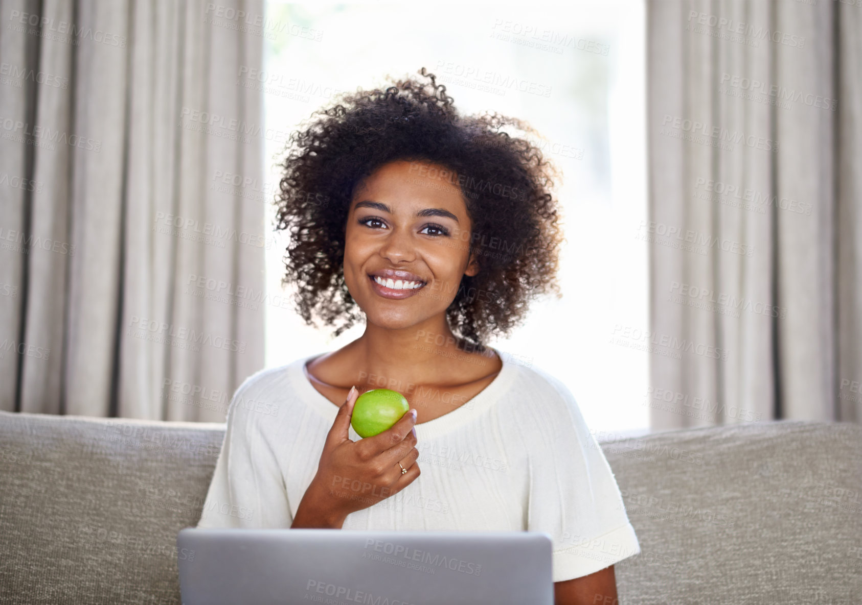 Buy stock photo Woman, apple and laptop on sofa for snack, wellness or diet for break, vitality or eat for health at home. Freelancer, smile and tech with green fruit for vitamin and nutrition for cleanse on couch