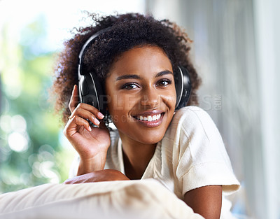Buy stock photo Portrait, music and smile with black woman in living room of home to relax on sofa for weekend time off. Face, streaming and headphones with happy young person on pillow in apartment for break
