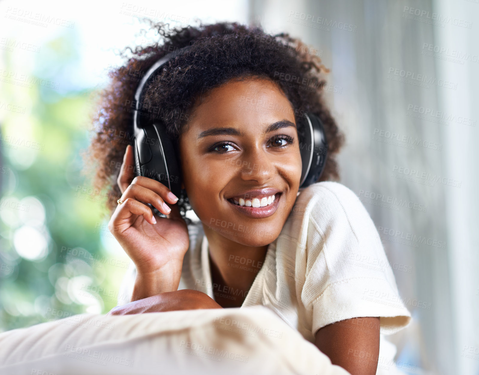 Buy stock photo Portrait, music and smile with black woman in living room of home to relax on sofa for weekend time off. Face, streaming and headphones with happy young person on pillow in apartment for break