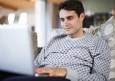 Buy stock photo Man, living room and sofa with typing on laptop for remote work as freelance journalist for newspaper and online research. Male person, home and focus on internet to search on information for article