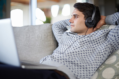 Buy stock photo Laptop, thinking and man with headphones in home to relax or listening to sound of radio podcast on sofa. Computer, music and dream of serious person in lounge for social media and streaming audio