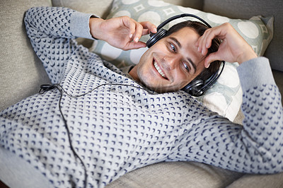 Buy stock photo Headphones, music and relax man in home lounge, sofa and streaming song for entertainment. Relax, weekend and technology for podcast or radio, internet and listening online to audio and happy 