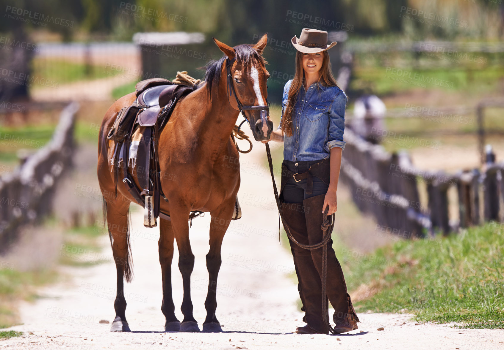 Buy stock photo Shot of a cow girl leading her horse around a ranch