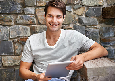 Buy stock photo Portrait of a young man smiling at the camera while holding his digital tablet outdoorsCropped shot of a man using his digital tablet while sitting on the deck