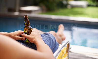 Buy stock photo Cropped shot of a man holding a beer at the poolside