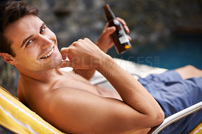 Buy stock photo Portrait, man and relax by swimming pool with beer to drink or chill on summer vacation, luxury and resort or villa. Male person, bottle and alcohol for refreshments on tropical holiday in Maldives.