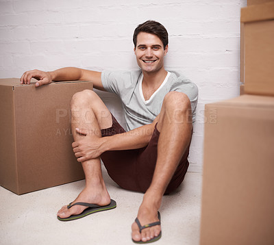 Buy stock photo Man, portrait and boxes on floor for moving with investment in real estate, new house and relax with happiness. Person, face and smile with cardboard on ground for storage, cargo and package in home