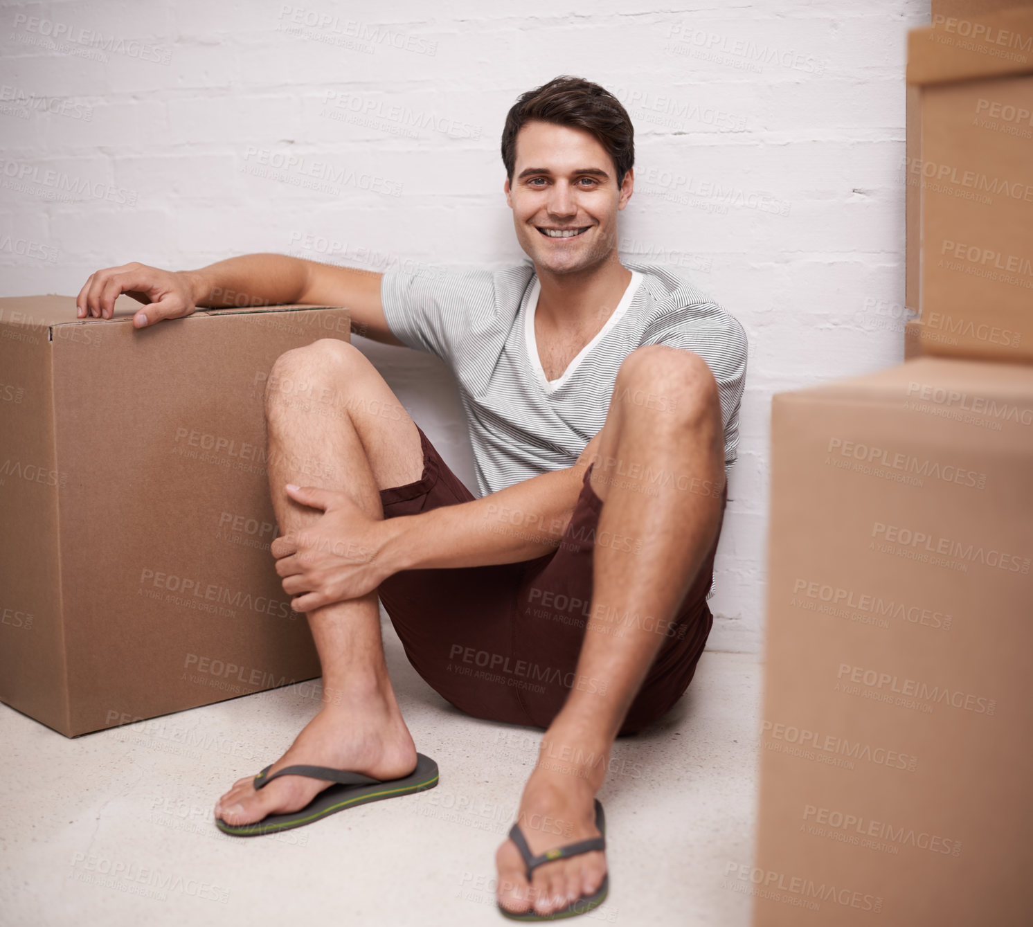 Buy stock photo Man, portrait and boxes on floor for moving with investment in real estate, new house and relax with happiness. Person, face and smile with cardboard on ground for storage, cargo and package in home