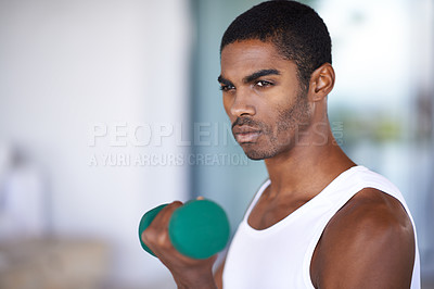 Buy stock photo A fitness shot of a young man toning with weights