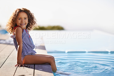 Buy stock photo Portrait of a happy little girl dipping her feet in the pool